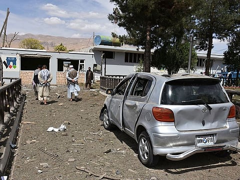 Afghan people inspect the site of a car bomb blast on an intelligence compound in Aybak, the capital of the Samangan province in northern Afghanistan, Monday, July 13, 2020.