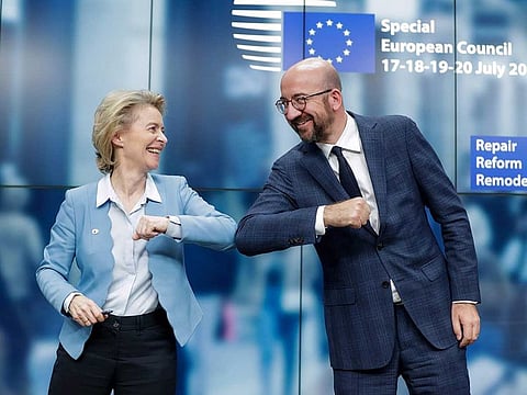 European Commission President Ursula Von Der Leyen (L) and European Council President Charles Michel (R) bump elbows at the end of the news conference following a four-day European summit at the European Council in Brussels, Belgium, early July 21, 2020