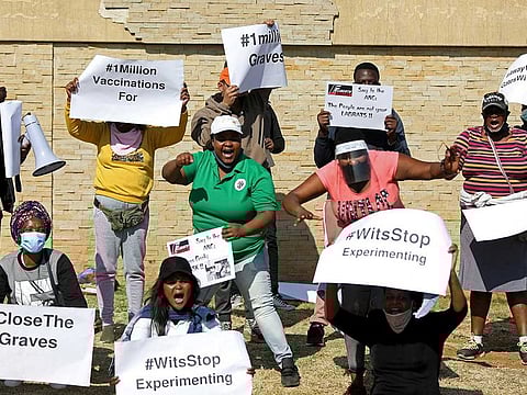 Protesters hold placards during a demonstration against the coronavirus disease (COVID-19) vaccine testing, outside Baragwanath hospital in Soweto, South Africa, July 18, 2020.