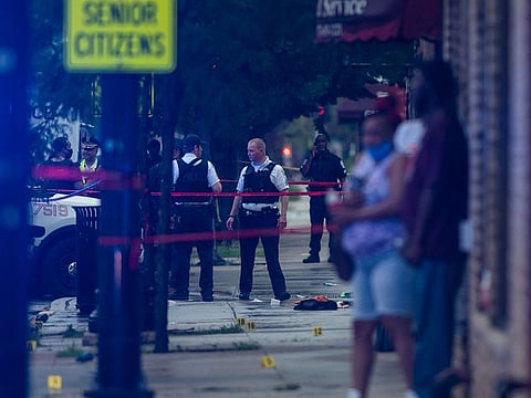 Chicago police investigate the scene of a mass shooting where more then a dozen people were shot in the Gresham neighborhood, of Chicago, Tuesday, July 21, 2020