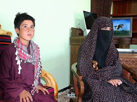 Qamar Gul, 16, right, and her brother Habibullah, 12, pose for photograph in the governor's office in Feroz Koh, the provincial capital of Ghor province, in western Afghanistan, Tuesday, July 21, 2020.