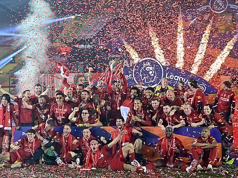 Liverpool's Jordan Henderson and teammates pose with the Premier League trophy during the presentation.