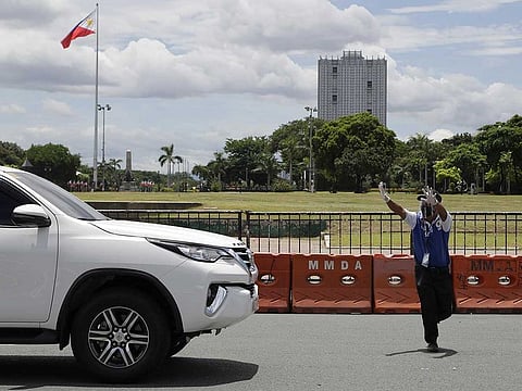 A man controls traffic at a free COVID-19 drive-thru testing facility in Manila, Philippines