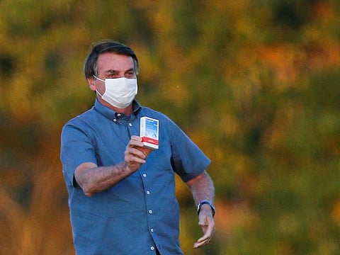 Brazil's President Jair Bolsonaro holds a box of chloroquine outside the Alvorada Palace, amid the coronavirus disease (COVID-19) outbreak in Brasilia, Brazil, July 23, 2020.