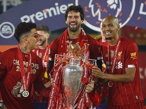 Fabinho, right, with Roberto Firmino and Alisson at the Liverpool Premier League title party.