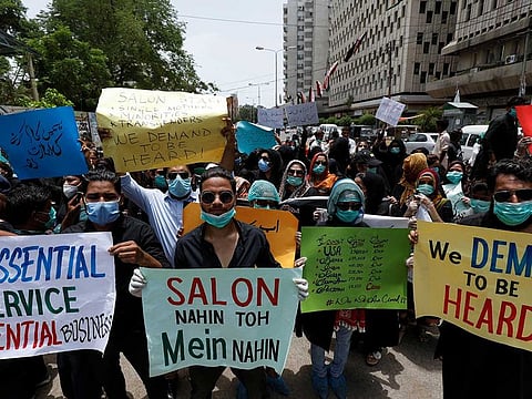 Salon workers hold signs during a protest demanding to reopen their business, after provincial government extended the ban on beauty parlours as a precautionary measures to stem the coronavirus disease (COVID-10) in Karachi, Pakistan July 22, 2020.
