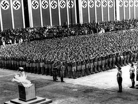 German Nazi soldiers line up in front of the Olympic torch during the opening ceremonies of the XI Summer Olympic Games at the Lustgarten in Berlin, Germany.