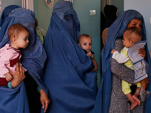 FILE. mothers hold their babies suffering from malnutrition as they wait at a UNICEF clinic in Jabal Saraj, north of Kabul, Afghanistan.