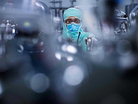 A lab technician dedicated to the vaccines formulation, wearing Personal Protective Equipment (PPE), prepares stainless steel tanks for manufacturing vaccines preparations before the syringe filling phase, at a French pharmaceutical company Sanofi's world distribution centre in Val-de-Reuil, France on July 10, 2020 . Pharma giants Sanofi and GSK said on July 29, 2020, that they have agreed to supply Britain with up to 60 million doses of a potential COVID-19 vaccine.