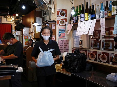 A worker holds a plastic bag containing a take-away lunch at a restaurant, following the coronavirus disease (COVID-19) outbreak in Hong Kong, China, July 29, 2020. Scientists in Hong Kong have shown genetic evidence confirming viral reinfection with SARS-CoV-2.