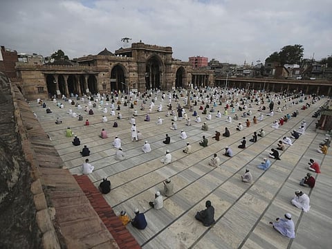 Indian Muslims sit while maintaining social distance and attend an Eid Al Adha prayers at the Jama Masjid in Ahmedabad, India, Saturday.