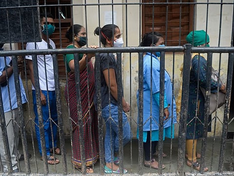 People recovered from the COVID-19 coronavirus, stand in a queue as they wait to donate blood plasma during a screening at a school in Dharavi, in Mumbai on July 23, 2020.