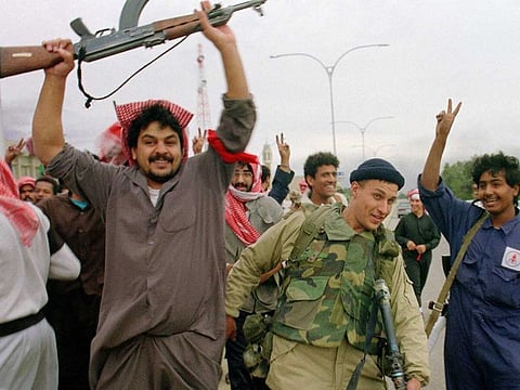Kuwaiti resistance fighters celebrate with a member of the US Marine Special forces on February 26, 1991, after the Marines entered the small town of Sabahiah, 9 miles from the capital of Kuwait City.