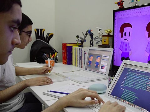 Pakistan's whiz kid duo, Kenan (foreground) and Nabhan busy designing the world's first COVID-19 video game at their home studio.