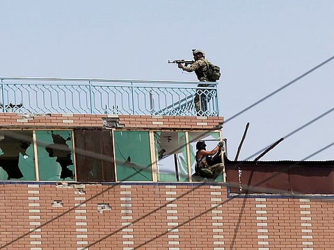 Afghan security forces take position on a building where the attackers were hiding after an attack on a jail compound in Jalalabad, Afghanistan August 3, 2020.