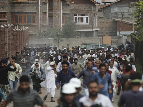 Kashmiris protesting against Modi government's stripping of the state’s semi-autonomous powers run for cover as police use tear gas and pellets to disperse them in Srinagar, last year. A year after India downgraded Kashmir to a federally governed territory, authorities have begun issuing residency and land ownership rights to outsiders for the first time in almost a century