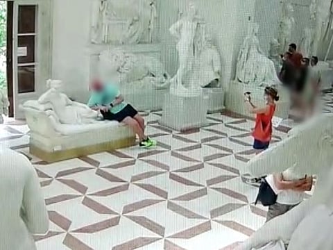 A tourist damaged a 19th-century sculpture after he sat on it to pose for a picture.