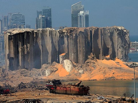 A damaged grain silo and a burnt boat at Beirut's harbour, one day after a powerful twin explosion tore through Lebanon's capital, resulting from the ignition of a huge depot of ammonium nitrate at the city's main port.