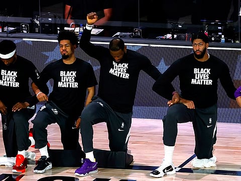 Los Angeles Lakers' LeBron James kneels during the national anthem prior to the NBA basketball game against the Oklahoma City Thunder
