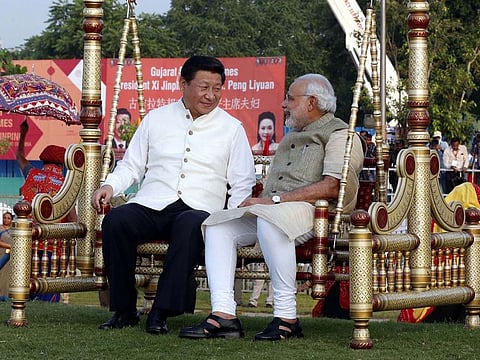 Chinese President Xi Jinping sits on a swing with Indian Prime Minister Narendra Modi at a riverside park in Gujarat in 2014