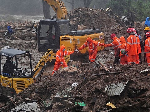 Rescue workers look for survivors at the site of a landslide during heavy rains in Idukki, on August 9, 2020.