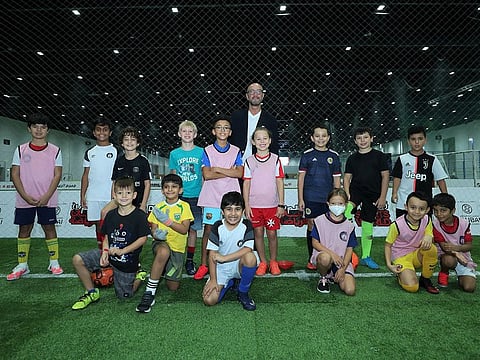 Walter Zenga, former Italian goalkeeper and decorated coach, poses with children during his visit at the Dubai Sports World.