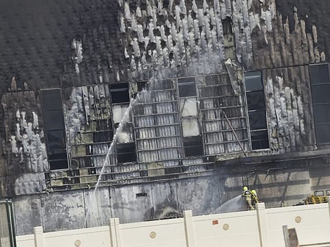 Civil defence personnel try to douse a fire that erupted at Dubai Duty Free warehouses in Umm Ramool on Monday.