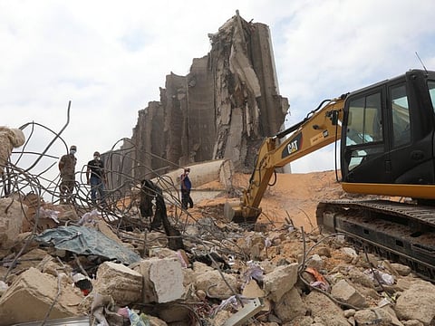 An excavator cleans debris near the damaged grain silo at the site of last week's blast at Beirut's port area.