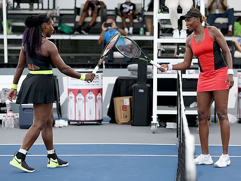 Serena Williams (L) and Venus Williams touch rackets after Serena won 3-6, 6-3, 6-4 during Top Seed Open on August 13, 2020 in Lexington, Kentucky.