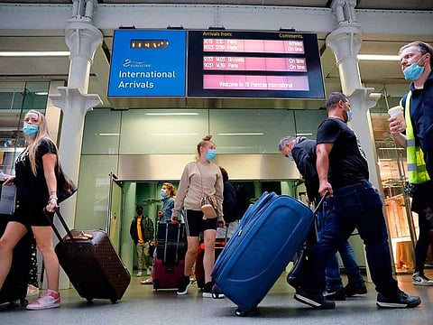 Passengers wearing facemasks as a precaution against the spread of the novel coronavirus walk through arrivals onto the main concourse at St Pancras International station in London on August 14, 2020 after travelling to London on a Eurostar train from Paris. Britain said it will reimpose quarantine from tomorrow for travellers from France and the Netherlands following a rise in coronavirus cases in those countries.