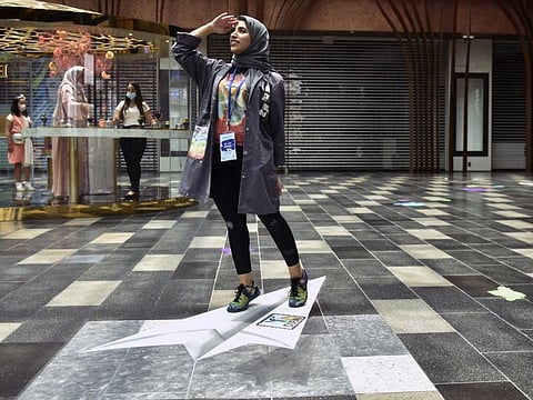 Mahra Al Falahi, a 23-year-old local artist, poses with one of her art pieces on display at the Dubai Canvas 2020 taking place at City Walk, Dubai.