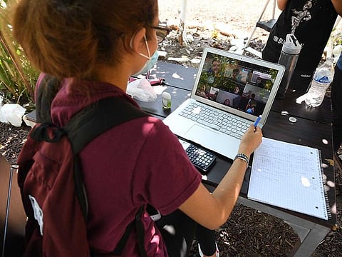 East College Prep High School senior Jocelyn Hernandez follows a remote Advanced Placement (AP) Calculus class while sitting in a community garden near her home, August 14, 2020 in the Boyle Heights neighborhood of Los Angeles, California.