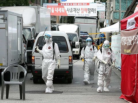 Public officials disinfect as a precaution against the coronavirus near the Sarang Jeil Church in Seoul, South Korea on Sunday, Aug. 16, 2020. South Korean health officials said on Monday that they found more than 300 coronavirus infections tied to a northern Seoul church led by one of President Moon Jae-in's biggest critics.