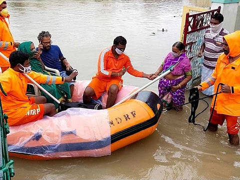 NDRF personnel rescue people on boats as floodwaters enter residential areas of Warangal on Monday.