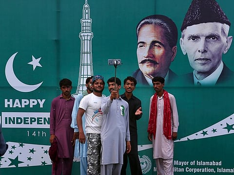 Pakistani youth take photographs in front of Happy Independence Day billboard with images of founder leader Muhammad Ali Jinnah and national poet Allama Muhammad Iqbal, displayed in Islamabad, Pakistan, Friday, August 14, 2020