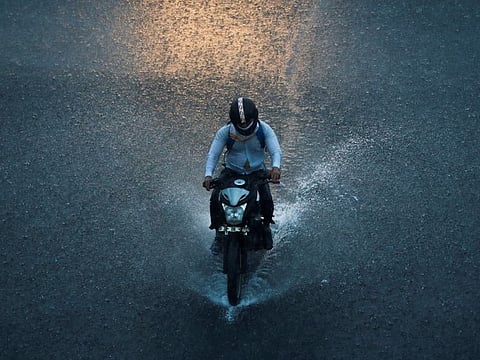 A man rides a motorbike during heavy rains in New Delhi, India