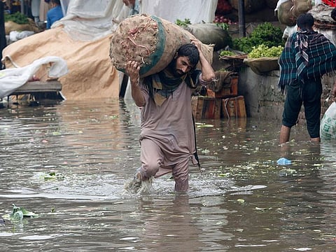 File image used for illustrative purposes: A laborer carries sack of onion while wades through a flooded area after heavy rainfall in Lahore, Pakistan, Thursday, Aug. 20, 2020.