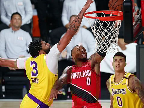 Los Angeles Lakers forward Anthony Davis blocks a shot by Portland Trail Blazers guard Damian Lillard