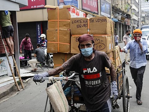 Two men wearing face mask to prevent coronavirus carry materials for delivery on a transport rickshaw in Kolkata, India, August 22. India now has the fourth most fatalities behind the United States, Brazil and Mexico.