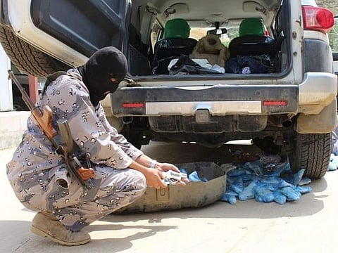 Saudi border guards pick through the haul of narcotics.