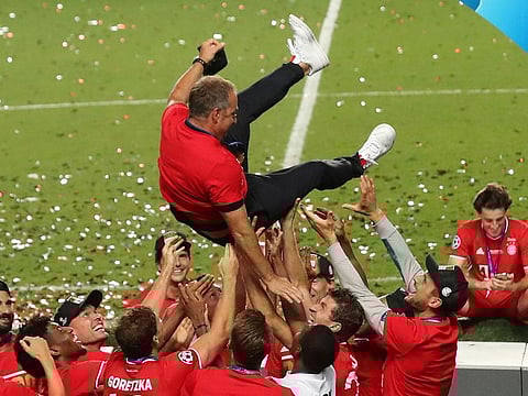 Bayern Munich players celebrate winning the Champions League crown last month as they throw coach Hansi Flick in the air.