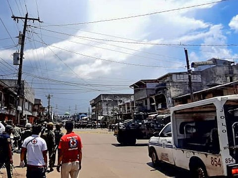 In this photo provided by the Philippine Red Cross, troopers secure an area after explosions struck the town of Jolo, Sulu province southern Philippines on Monday Aug. 24, 2020.