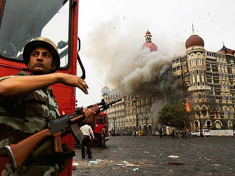 Indian security forces take cover during a heavy exchange of gunfire with terrorists outside the historic Taj Mahal hotel Mumbai on November 28, 2008.