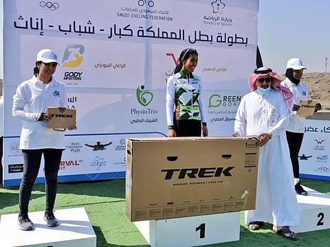 Ahlam Al Zaid collects her medal on the podium after winning the race.
