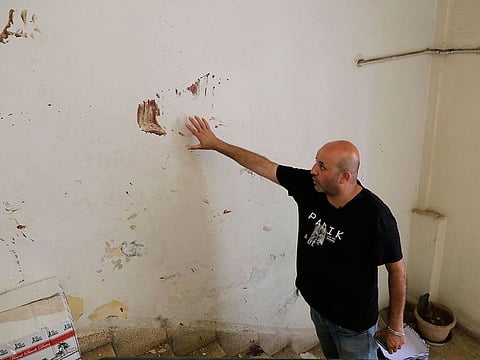 Syrian national Bilal points out on August 19, 2020 to the blood stains of his injured children and wife left on the walls of the building stairs as they were rushed to the hospital on the day of Beirut's port massive chemical explosion that shook the Lebanese capital, in Gemmayzeh neighbourhood.