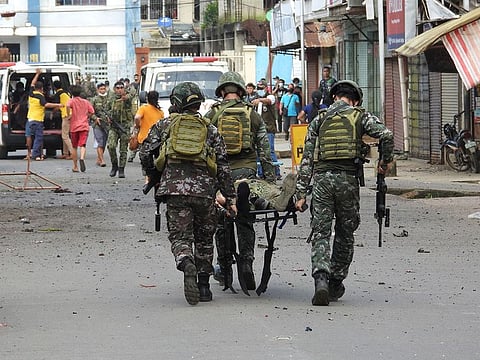 Soldiers stretcher away a comrade after an improvised bomb exploded next to a military vehicle in the town of Jolo on Sulu island on August 24, 2020.