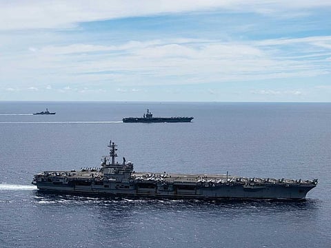 The USS Ronald Reagan (CVN 76, front) and USS Nimitz (CVN 68, rear) Carrier Strike Groups sail together in formation, in the South China Sea.