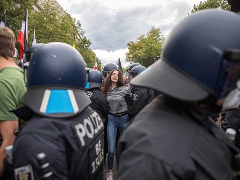 The police detain a woman during a demonstration against COVID-19 measures, in Berlin, Germany, Saturday, Aug. 29, 2020.