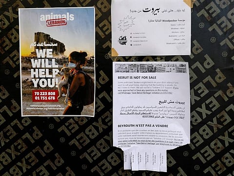 A flyer warning Lebanese residents from property sharks attempting to buy their damaged homes is plastered on the wall of a building in the Gemmayzeh neighbourhood, in the capital Beirut, by volunteers from the "Save Beirut Heritage" action group, on August 19, 2020.