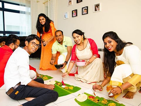 Monika Deepak with her family members. The traditional ‘Onasadhya’ meal served on banana leaves is integral to the festival.